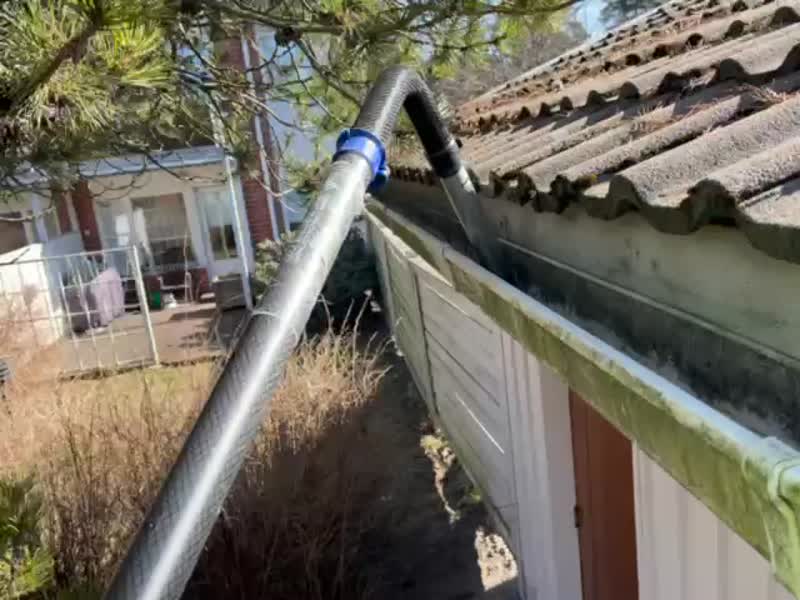 Vacuum hose in a moss-covered gutter